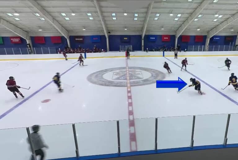Example of a hockey recruiting video by Chris Schieman Media. In the example image, the player is marked with a blue arrow pointing at him, as he begins his attack into the blue zone.